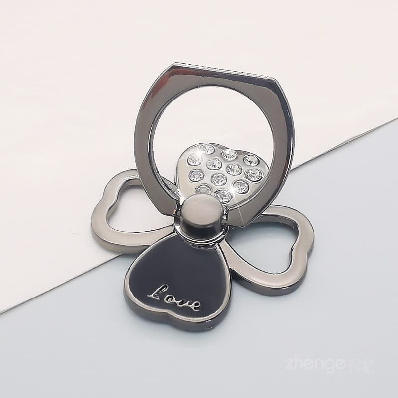 Black clover-shaped ring stand with rhinestone accents